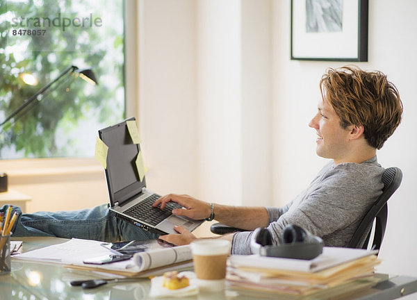Mann mit Laptop im home-office Heimarbeitsplatz
