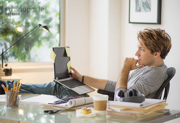 Mann mit Laptop im home-office Heimarbeitsplatz