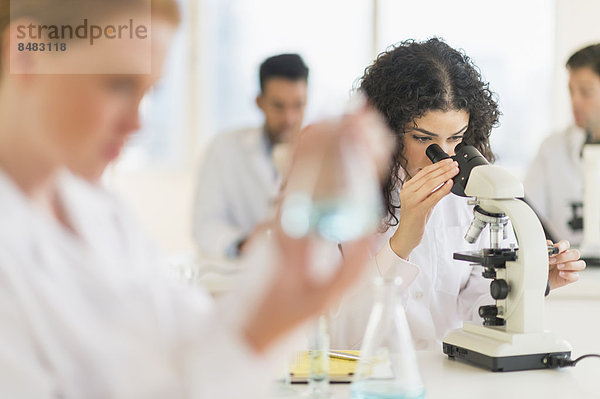Wissenschaftler schaut in Mikroskop