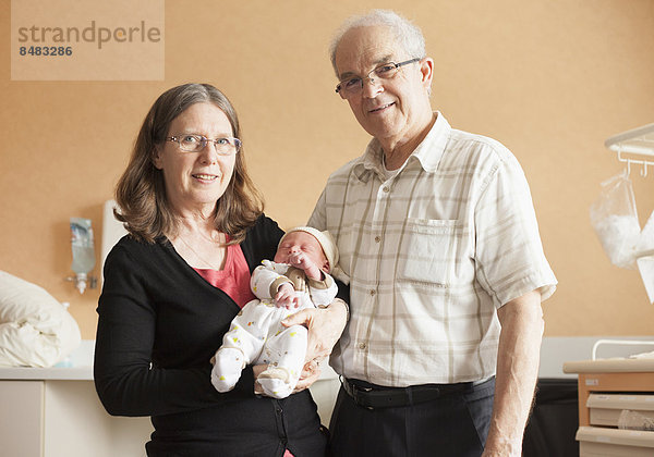 Senior Senioren Neugeborenes neugeboren Neugeborene Europäer halten Enkelsohn