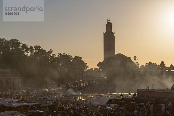 Nordafrika  entfernt  Abend  Beleuchtung  Licht  beschäftigt  Quadrat  Quadrate  quadratisch  quadratisches  quadratischer  UNESCO-Welterbe  Marrakesch  Koutoubia-Moschee  Afrika  Minarett  Marokko  Moschee  Platz