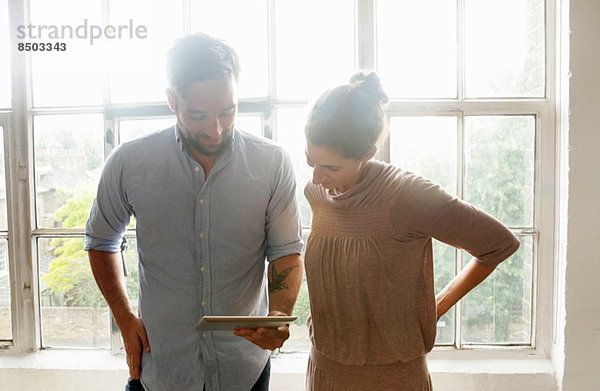 Mittleres erwachsenes Paar mit digitalem Tablett