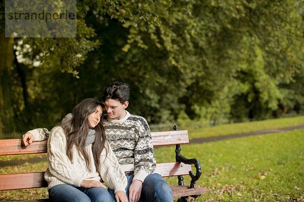 Junges Paar auf Parkbank sitzend