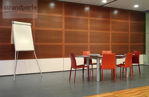 Flipchart und rote Stühle im Konferenzraum