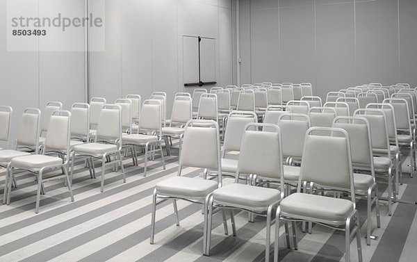 Weiße Stühle im leeren Hörsaal