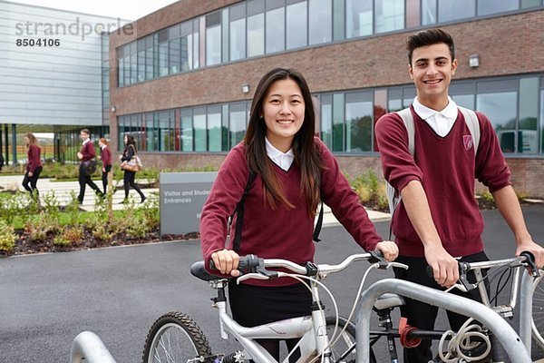 Teenager-Freunde mit Fahrrädern außerhalb der Schule