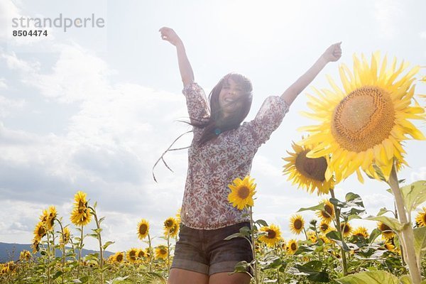 Mittlere erwachsene Frau im Feld der Sonnenblumen