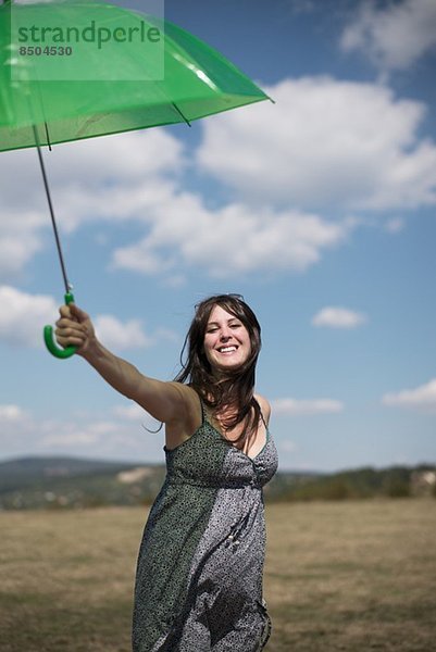 Mittlere erwachsene Frau mit grünem Regenschirm