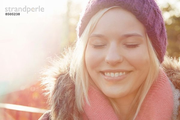 Portrait einer jungen Frau mit Strickmütze  Augen geschlossen