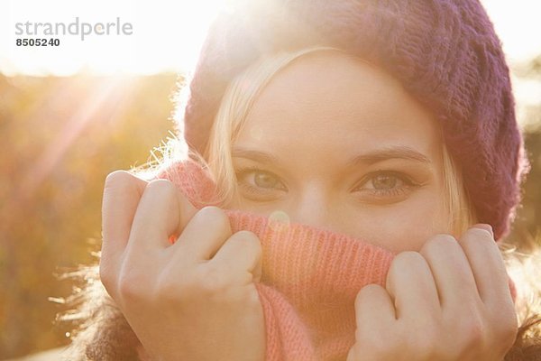 Portrait einer jungen Frau mit Strickmütze  Mund bedeckt