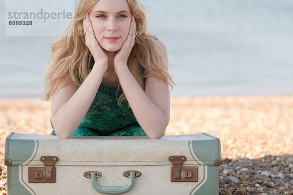 Portrait einer jungen Frau mit Koffer am Strand  Whitstable  Kent  UK