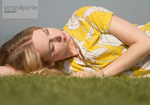 Porträt einer jungen Frau  die auf Gras träumt