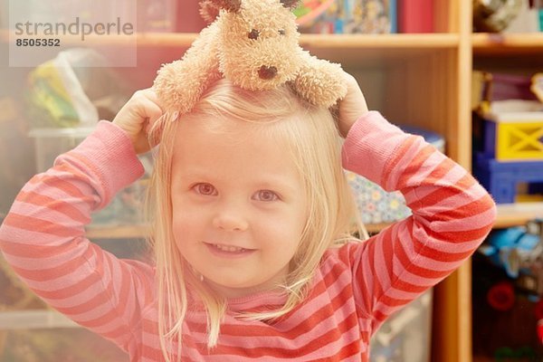 Porträt eines Mädchens mit Teddybär auf dem Kopf
