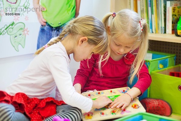 Zwei Mädchen spielen mit Puzzle bei Zahnärzten