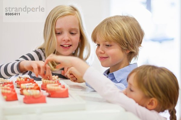 Kinder  die auf künstliche Zähne schauen