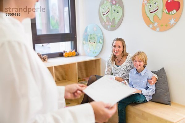 Mutter und Sohn im Wartezimmer des Zahnarztes