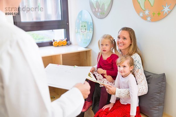 Mutter mit Töchtern im Wartezimmer des Zahnarztes