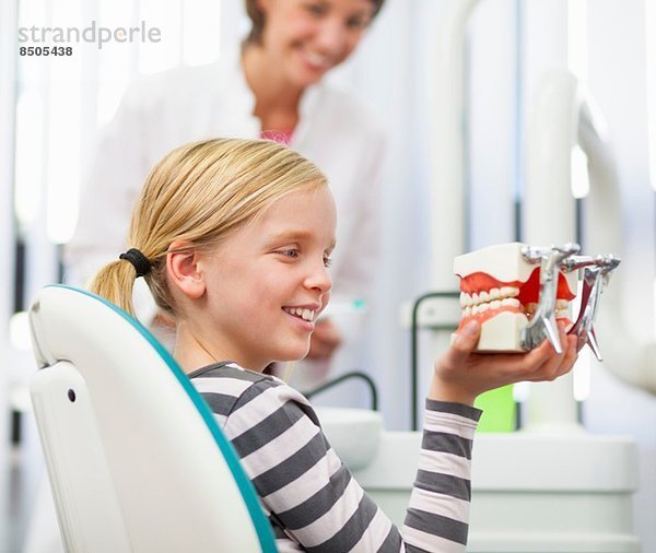 Mädchen im Zahnarztstuhl mit falschen Zähnen