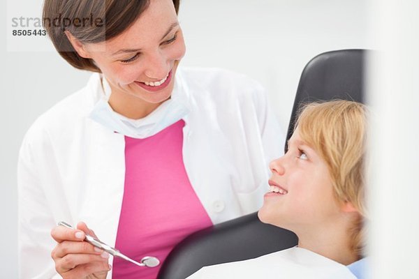 Junge wird untersucht  Zahnarzt hält Zahnspiegel