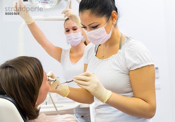 Zahnärztin  die an einer Patientin arbeitet