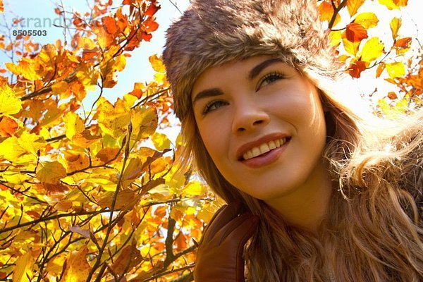 Junge Frau mit Pelzmütze im Herbstpark