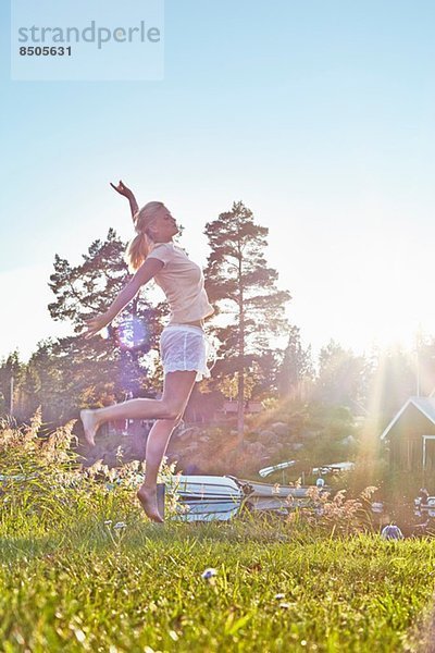Junge Frau springt am See  Gavle  Schweden