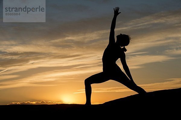 Silhouette einer jungen Frau beim Yoga  Moab  Utah  USA