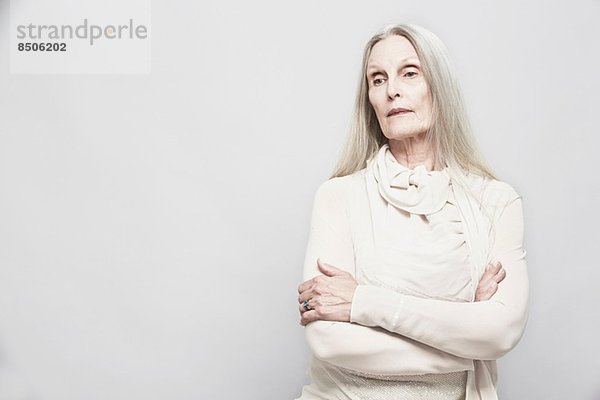 Studio-Porträt einer älteren Frau mit gekreuzten Armen