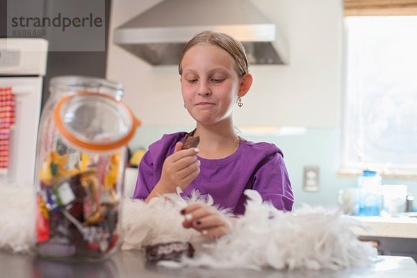 Mädchen genießt heimlich Keks aus dem Keksfass