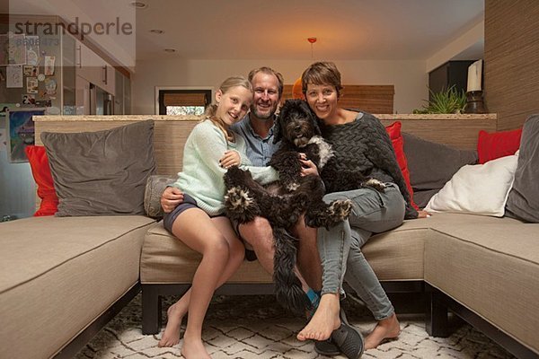 Porträt von Eltern  Tochter und Hund auf Sofa