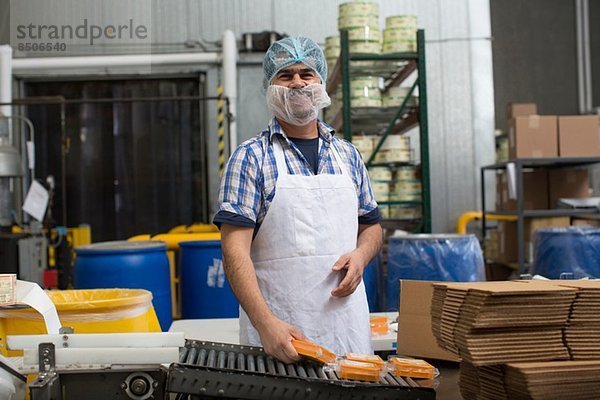 Mann verpackt veganen Käse im Lagerhaus