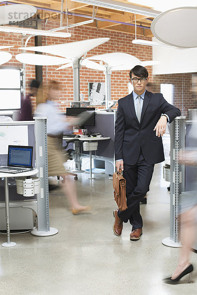 Businessman standing in busy office