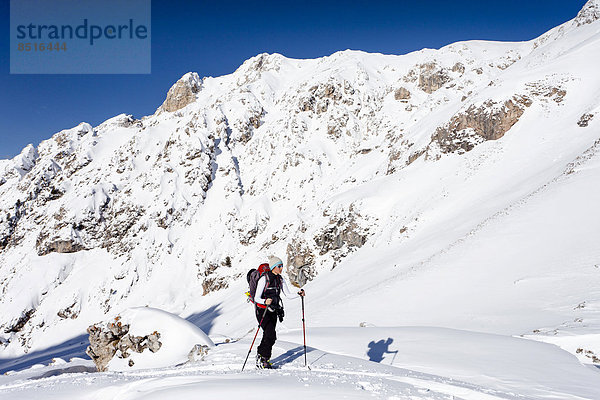 Skitourengeher beim Aufstieg auf den Zendleser Kofel im Villnösstal  hinten die Aferer Geisler  Dolomiten  Südtirol  Italien