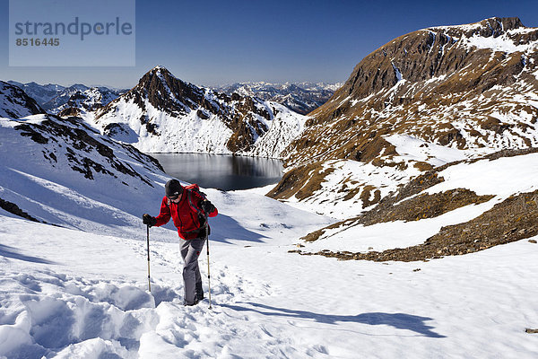 Bergsteiger beim Aufstieg auf die Wilde Kreuzspitze in den Pfunderer Bergen  hinten der Wilde See und die Kalkgrubenspitze  Eisacktal  Südtirol  Italien