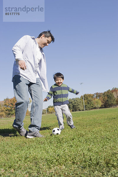 Außenaufnahme Menschlicher Vater Sohn Hispanier Fußball freie Natur spielen
