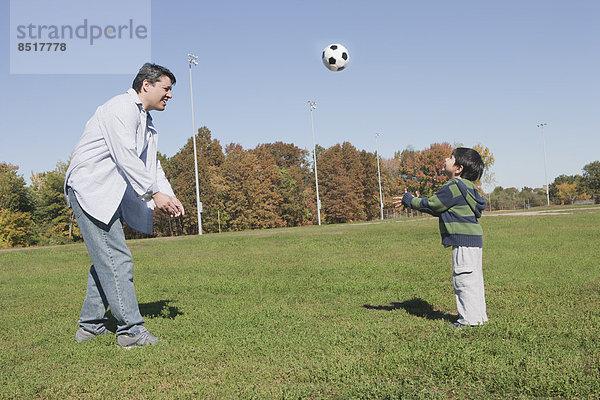 Außenaufnahme Menschlicher Vater Sohn Hispanier Fußball freie Natur spielen