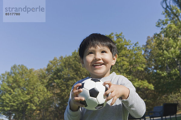 Außenaufnahme Junge - Person Hispanier Fußball freie Natur spielen