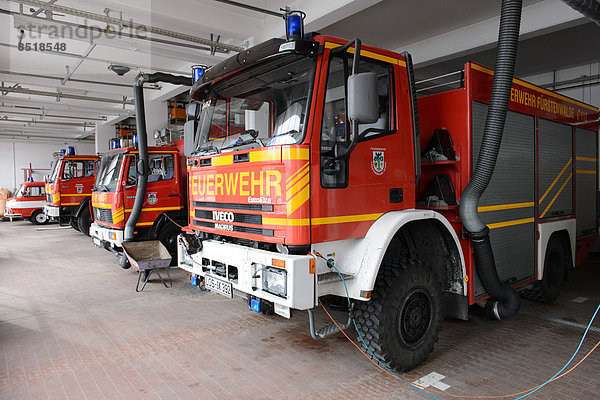 Feuerwehrfahrzeuge in einer Feuerwehrwache.