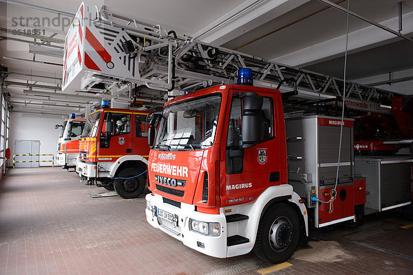 Feuerwehrfahrzeuge in einer Feuerwehrwache.