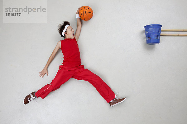Junge spielt Basketball