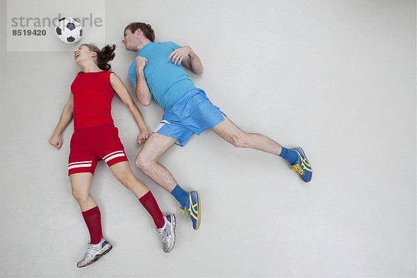Mann und Frau springen nach dem Fußball