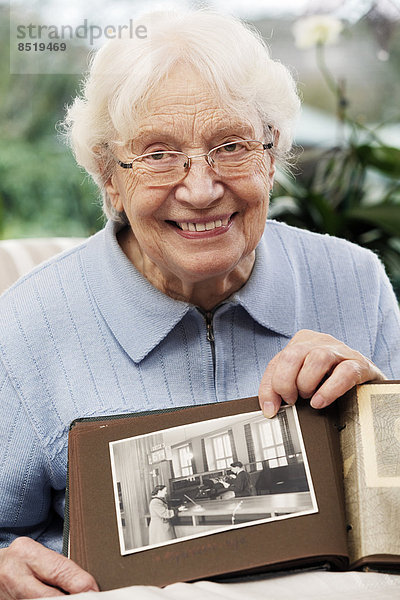 Ältere Frauen zeigen ein altes Foto von sich selbst