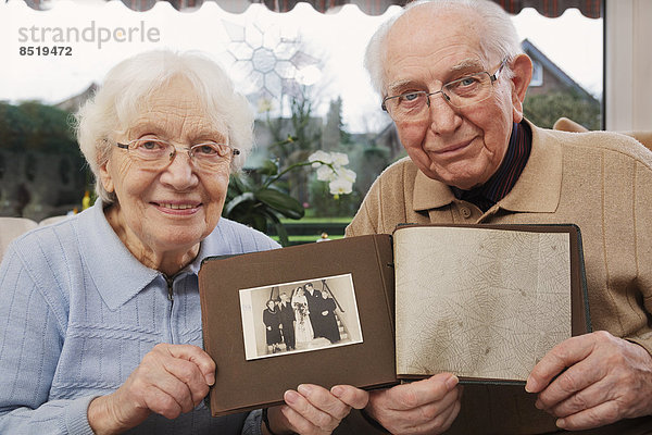 Seniorenpaar zeigt altes Foto vom Hochzeitstag