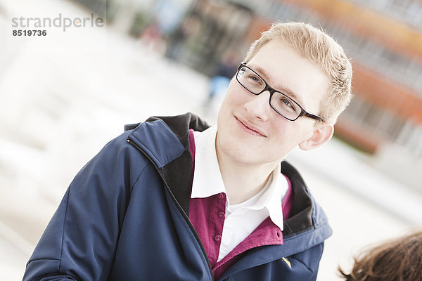 Lächelnder junger Mann mit Brille im Freien
