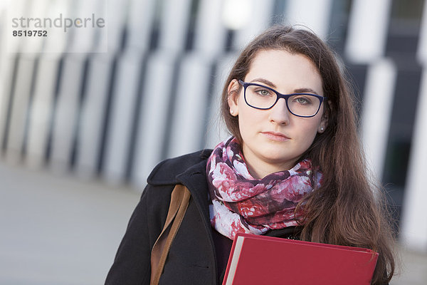 Student with folder outdoors  portrait