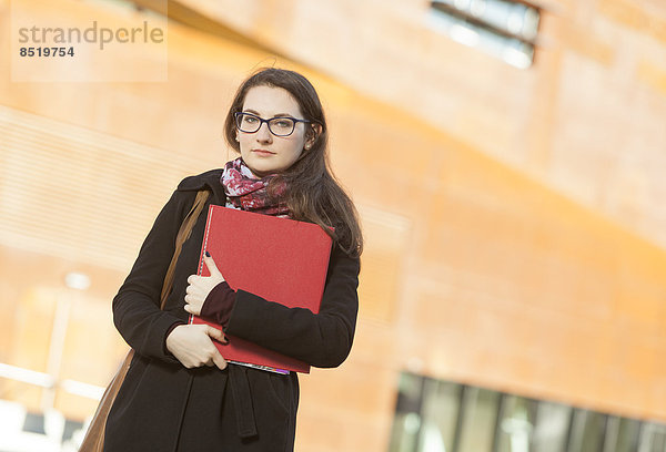 Student mit Mappe im Freien  Portrait