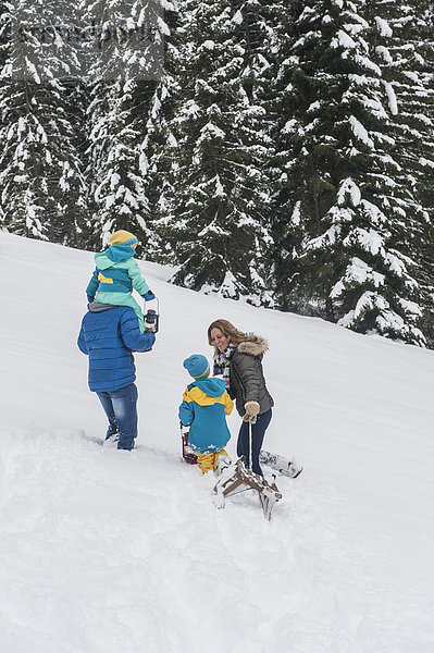 Austria  Salzburg Country  Altenmarkt-Zauchensee  Family walking in snow  pulling sledge