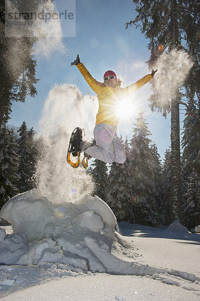 Austria  Salzburg State  Altenmarkt-Zauchensee  Woman with snowshoes jumping in winter landscape