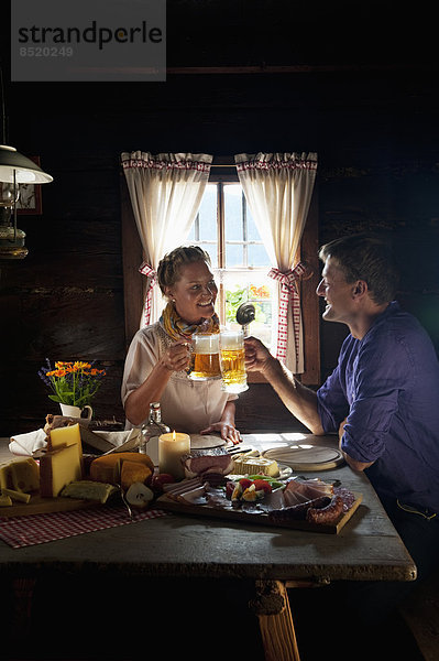 Austria  Salzburg State  Altenmarkt-Zauchensee  couple haßing an alpine picnic at alpine cabin
