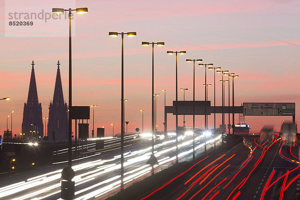 Deutschland  Nordrhein-Westfalen  Kölner Dom und Straßenverkehr auf der beleuchteten Zoobrücke bei Dämmerung